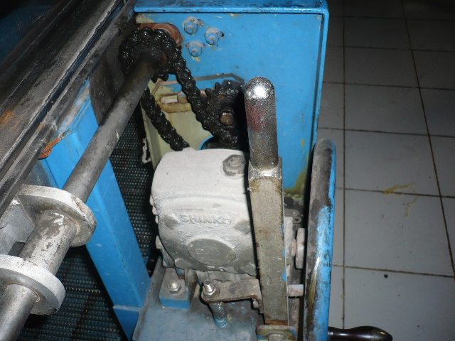 Sistem penggerak konveyor menggunakan rantai dan sprocket terbuka yang memerlukan pelumasan.