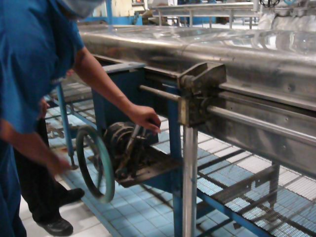 Operator sedang mengoperasikan mekanisme manual untuk membuka penutup steambox.