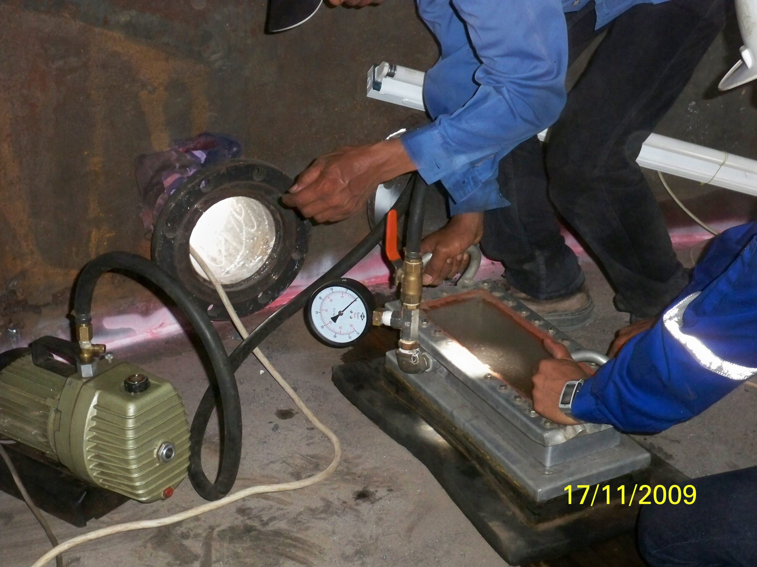 Tim teknisi sedang melakukan pengujian kebocoran las menggunakan metode Vacuum Box Test di dalam tangki.
