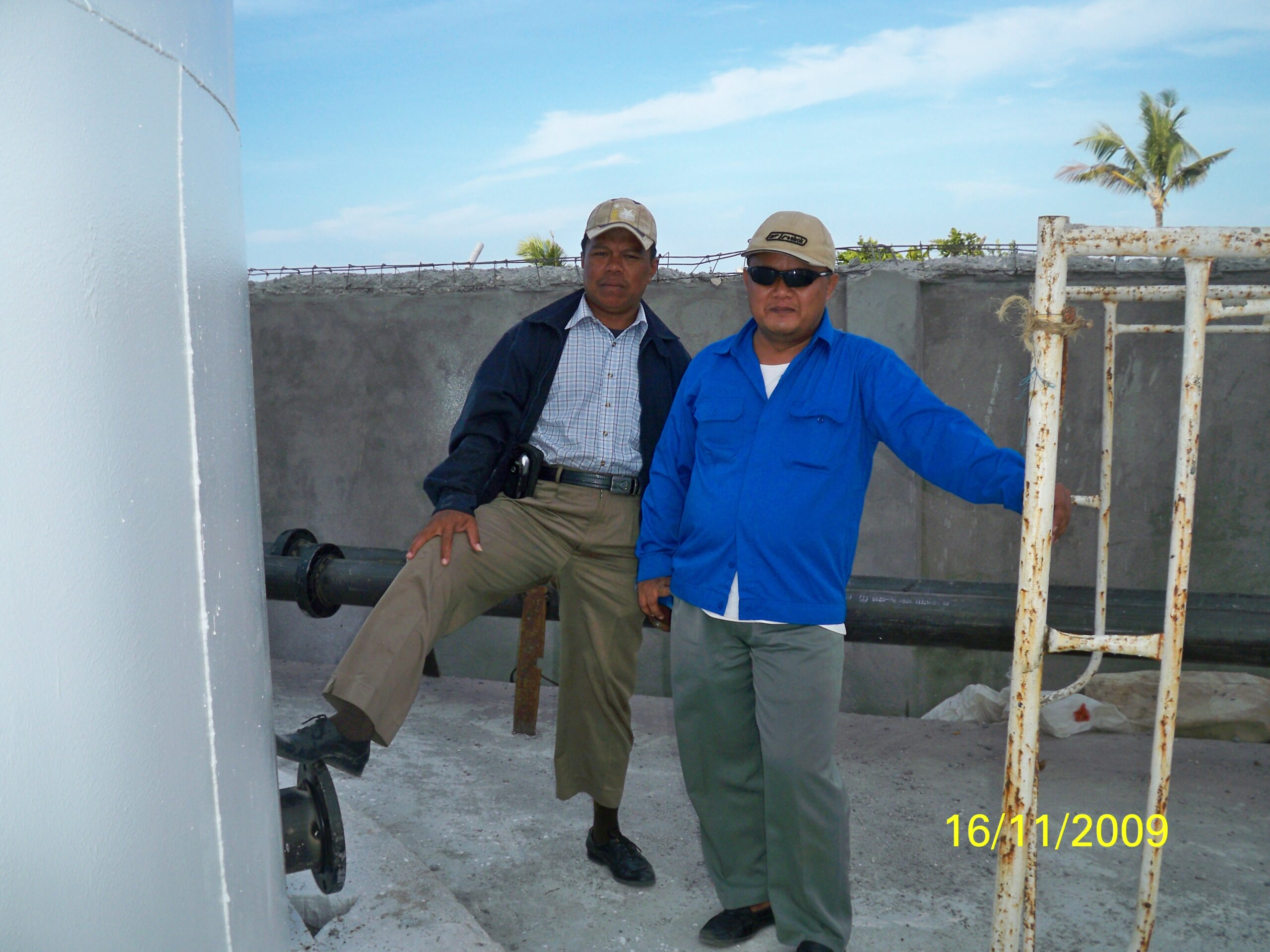 Dua orang manajer proyek atau supervisor berfoto di lokasi proyek tangki Selayar.