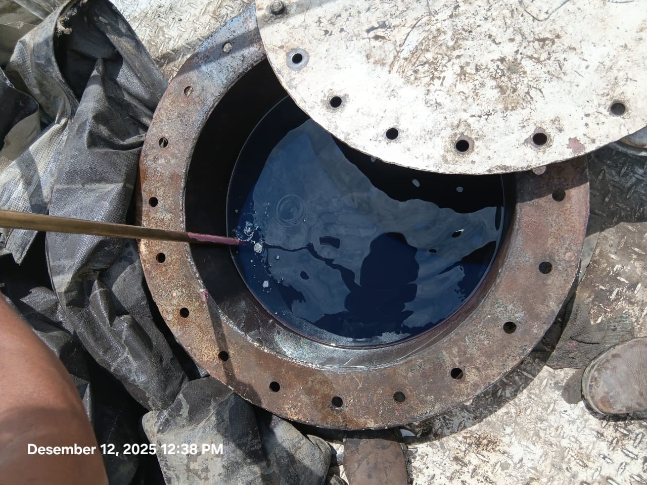 Proses inspeksi manual oleh personel klien untuk memeriksa level bahan bakar dan endapan melalui manhole utama.