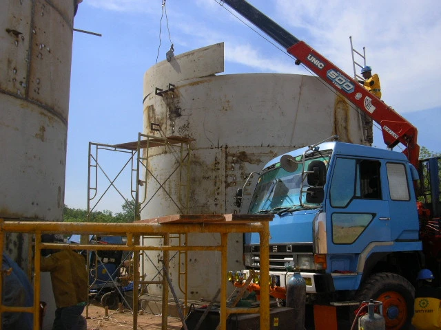 Operasi pengangkatan segmen tangki menggunakan crane.