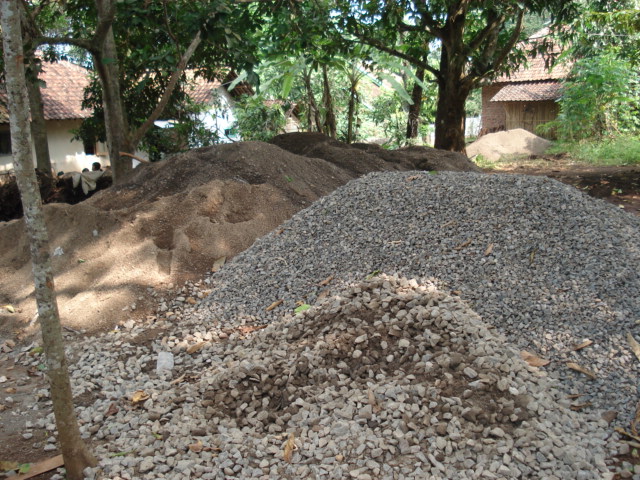 Tumpukan agregat konstruksi, pasir dan kerikil, di lokasi proyek.